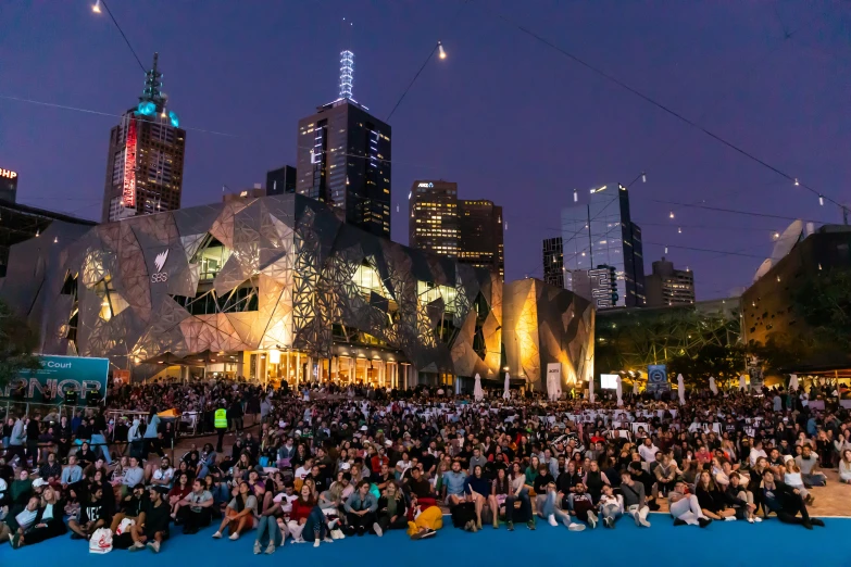 a crowd gathers in front of a building at night