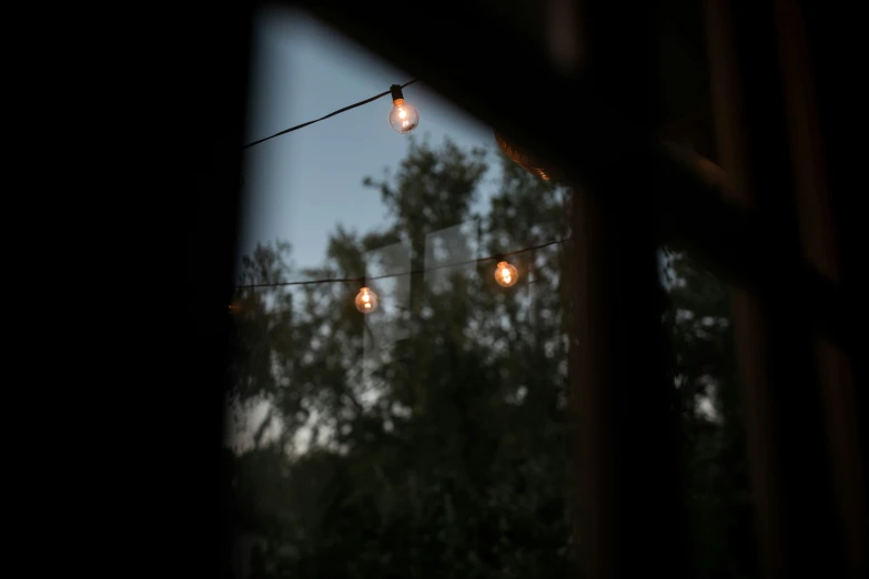 glowing bulbs hanging from a wire at night