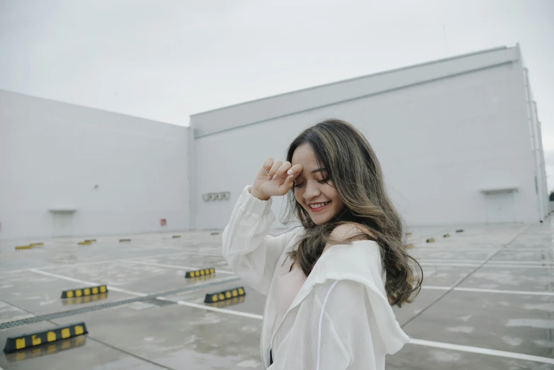 a smiling woman standing outside an industrial facility