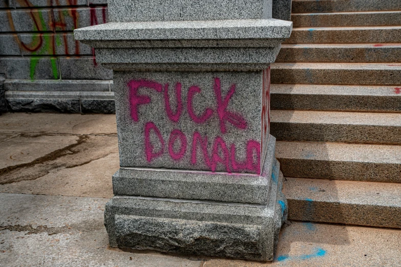 a cement pillar with graffiti writing on it