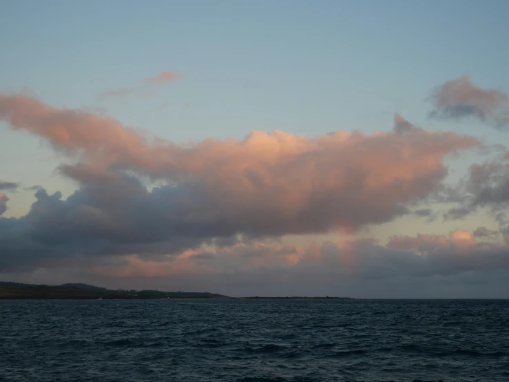 clouds are shown above the ocean with a large ship floating in it