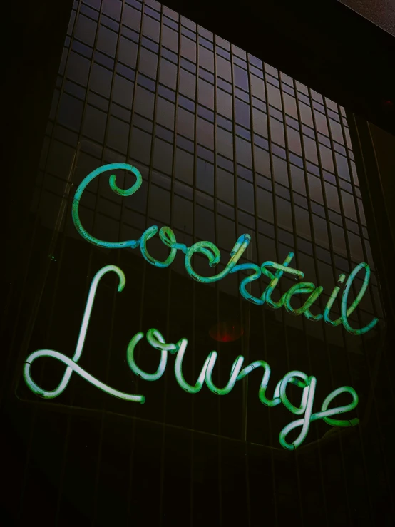 a neon sign in front of a building reading cocktail lounge