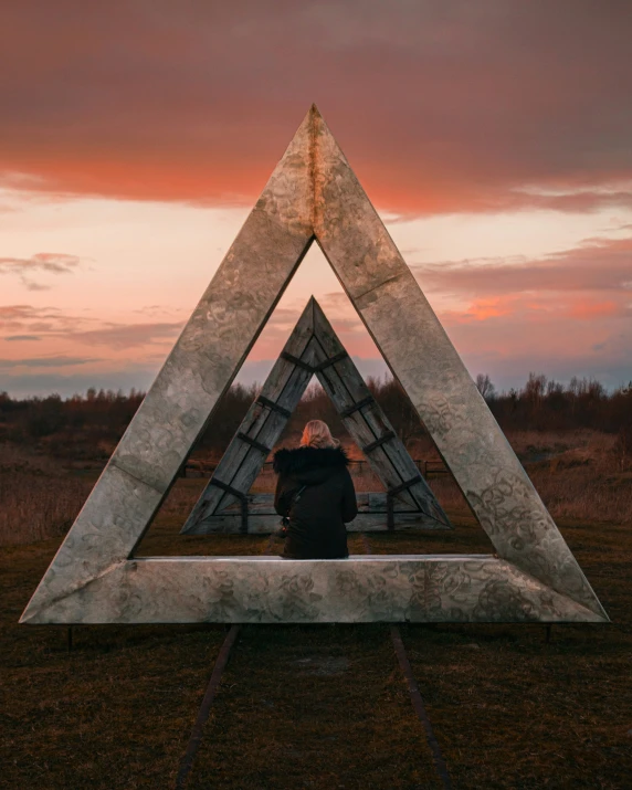 a person standing in front of a metal sculpture