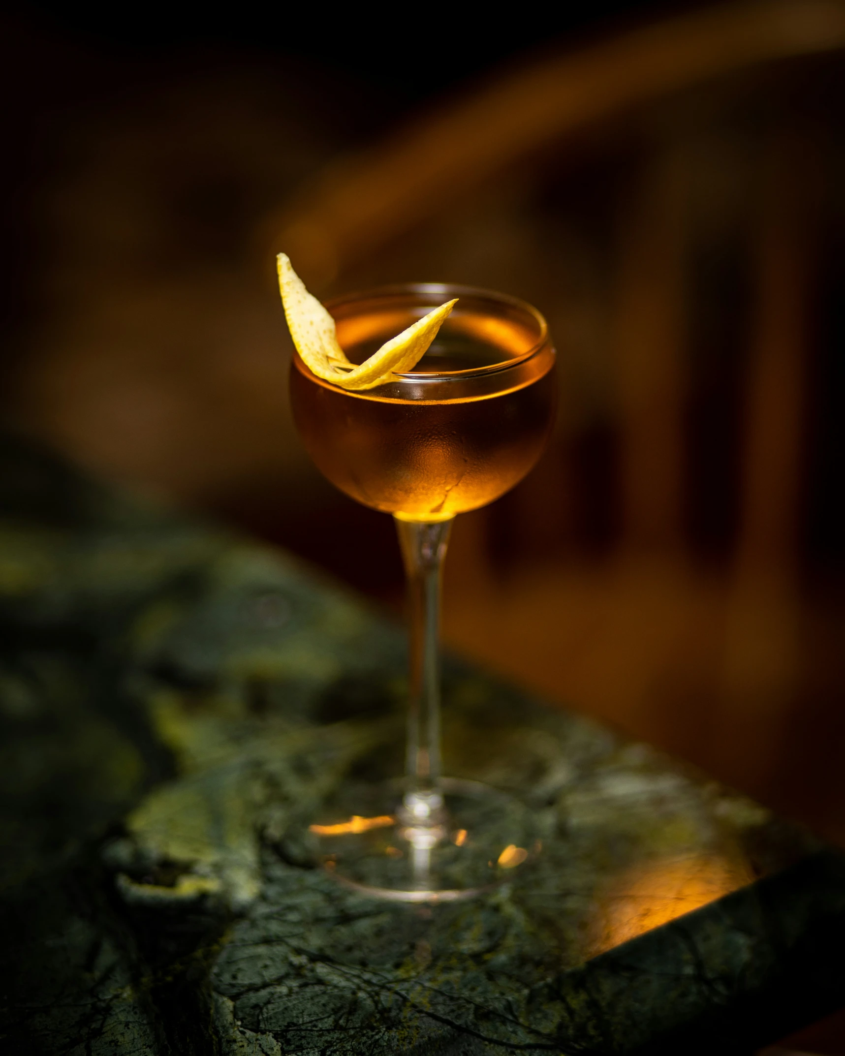 a drink is sitting on a table, with an orange slice in the glass