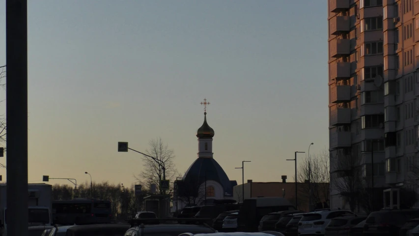 view of a large building with a steeple and an illuminated cross on top