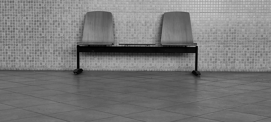 two chairs on top of a desk sitting next to a brick wall