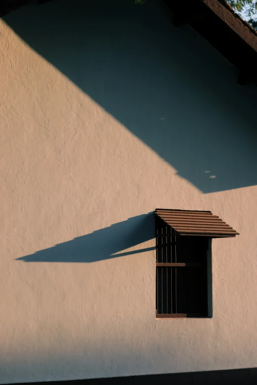 a small window above a tiny awning on a building