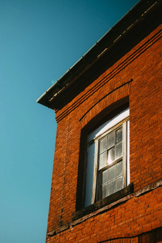 the corner of an old brick building with a window