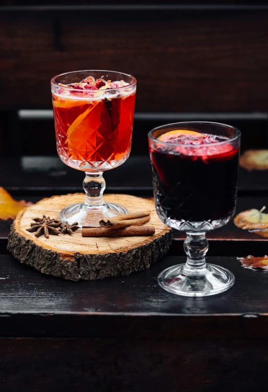 two cocktails are shown sitting on a  board