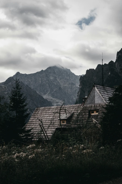 an abandoned house sits in front of mountains