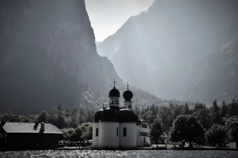 a church sitting in a valley surrounded by mountains