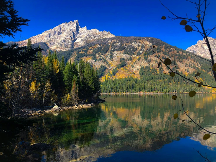 the mountains stand tall on the clear blue water