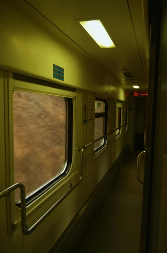 a train with open windows next to a green floor
