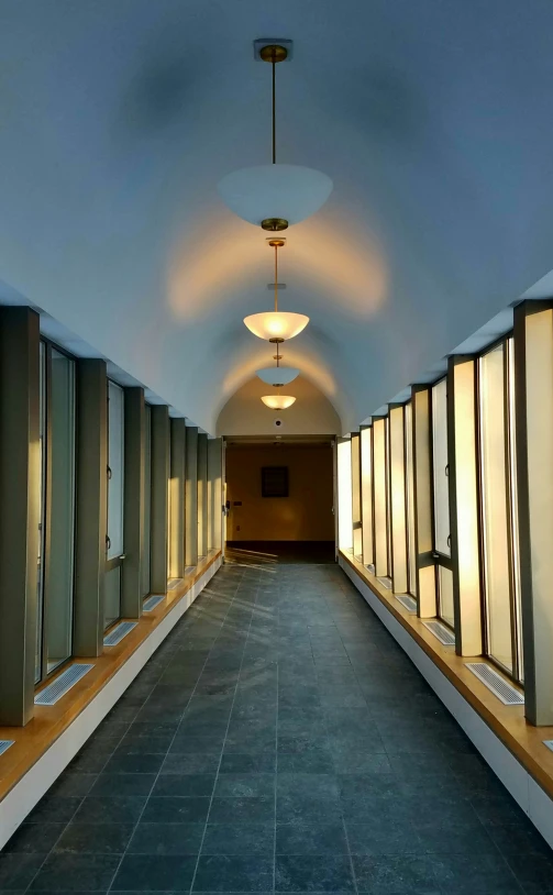 a long corridor in a large building with lots of windows