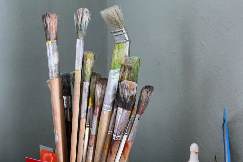 a wooden table holding a bunch of brushes and brushes