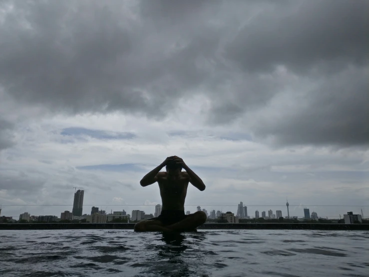 a man in the middle of the water in front of the city