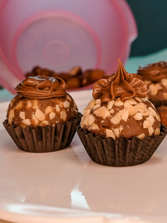 chocolate covered cupcakes are on a plate with candy in the background