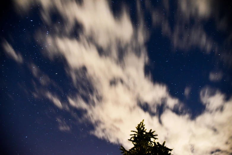 the night sky is covered with clouds and stars