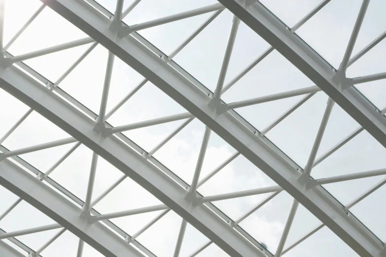 the underside of a building with lots of glass and a jet flying by