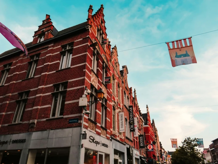 red building along street near cloudy blue sky