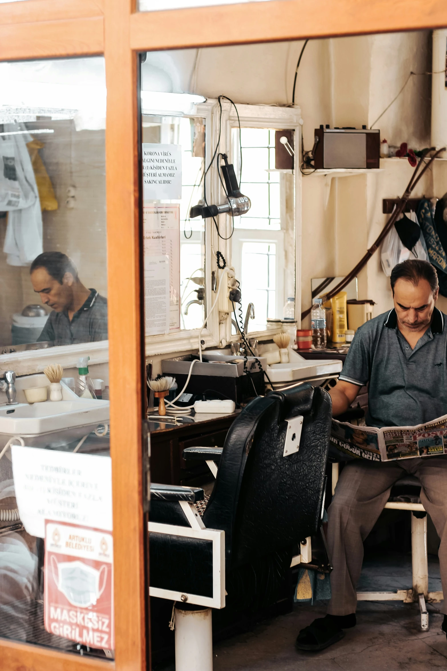 the man is sitting with newspaper in his hands