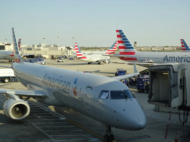 an american airlines jetliner on the tarmac with airplanes at an airport