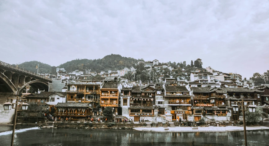 a river has houses on it and buildings on the hillside