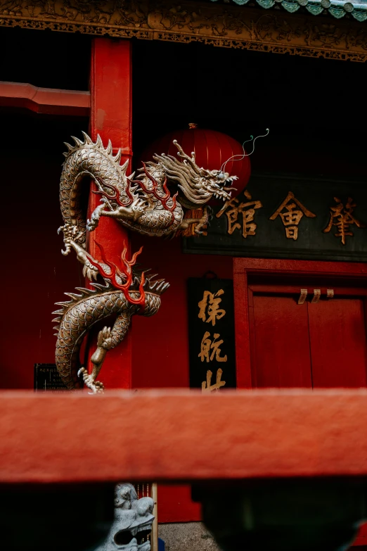 a red and yellow dragon statue sitting under a building