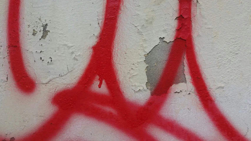 graffiti on the side of a wall with red spray paint