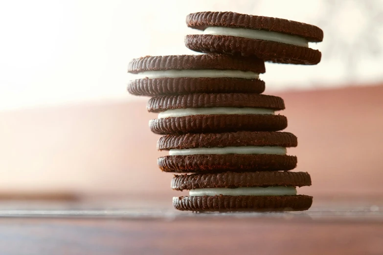 stack of chocolate cookies with white icing on a table