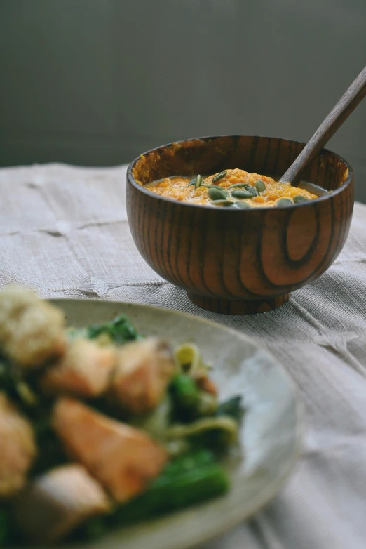 the meal is served in a wooden bowl with silverware