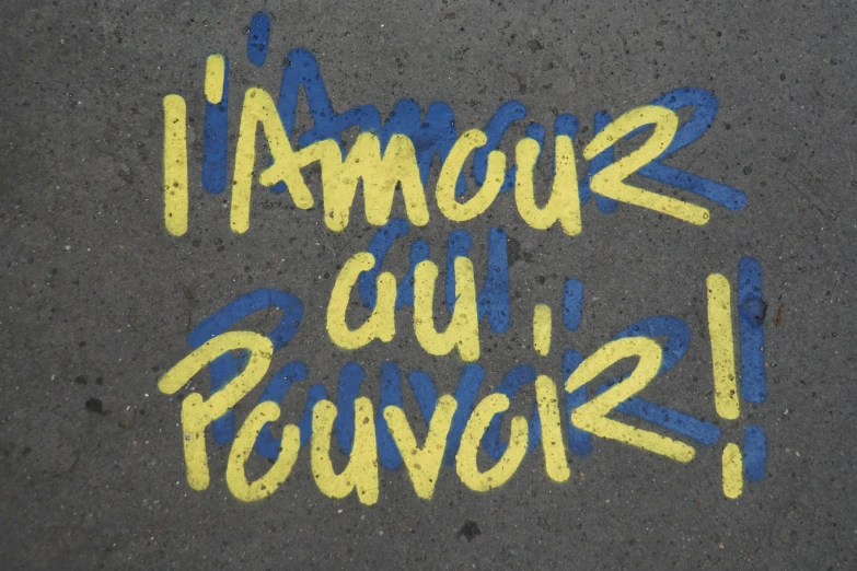 street writing on pavement that reads i ameur du revour