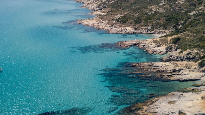 a boat floating on the blue water near a shore