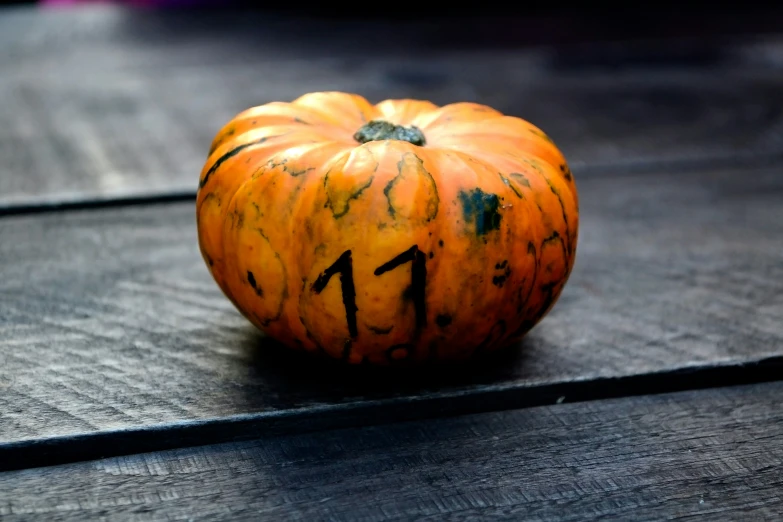 an orange pumpkin sitting on top of a wooden table