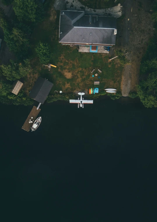 an airplane flying over a house in a lake