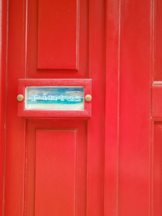 an red door with a sign mounted on it