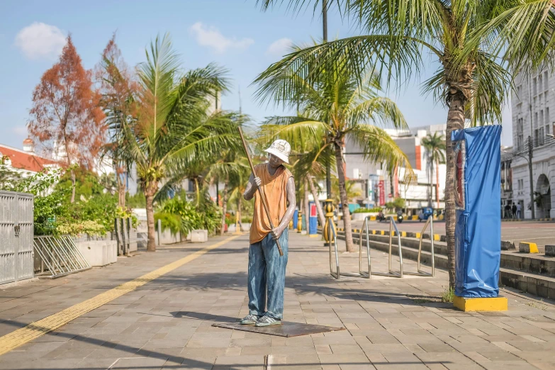 a man with a baseball cap standing on a brick road