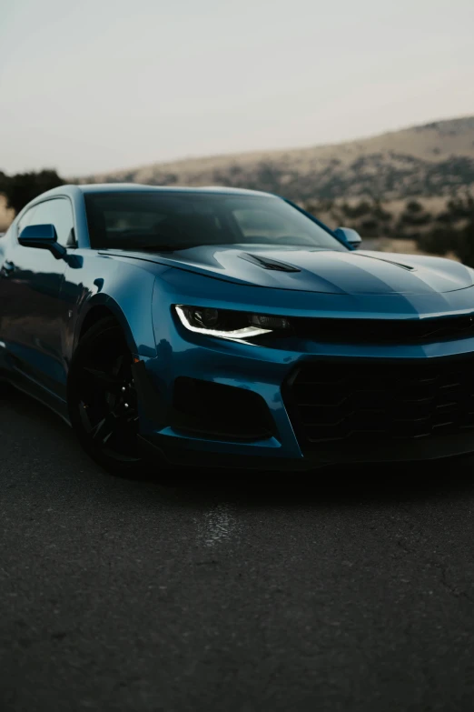 the front of a sports car that is driving down a highway