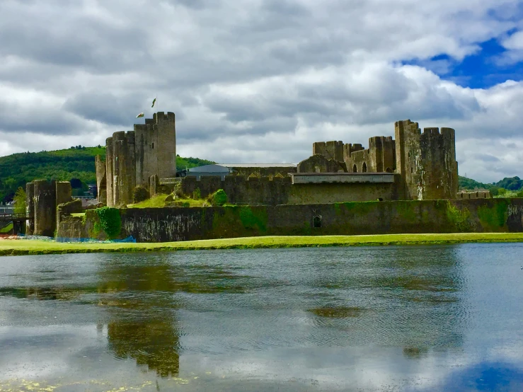 a large castle with several towers is reflected in a body of water