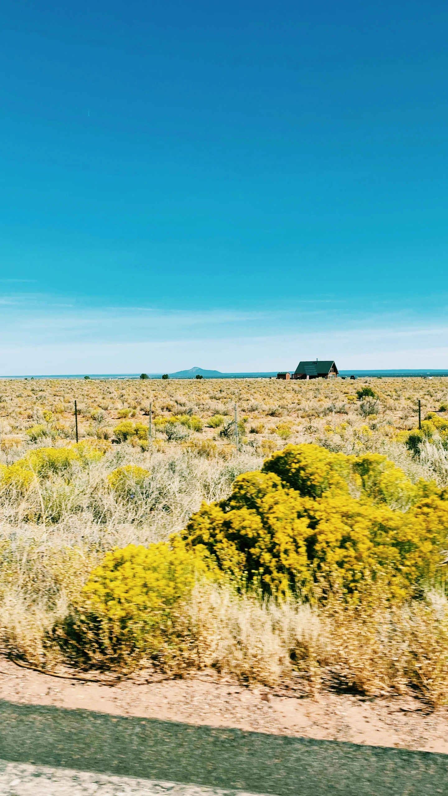 a car drives past a lonely building in the desert