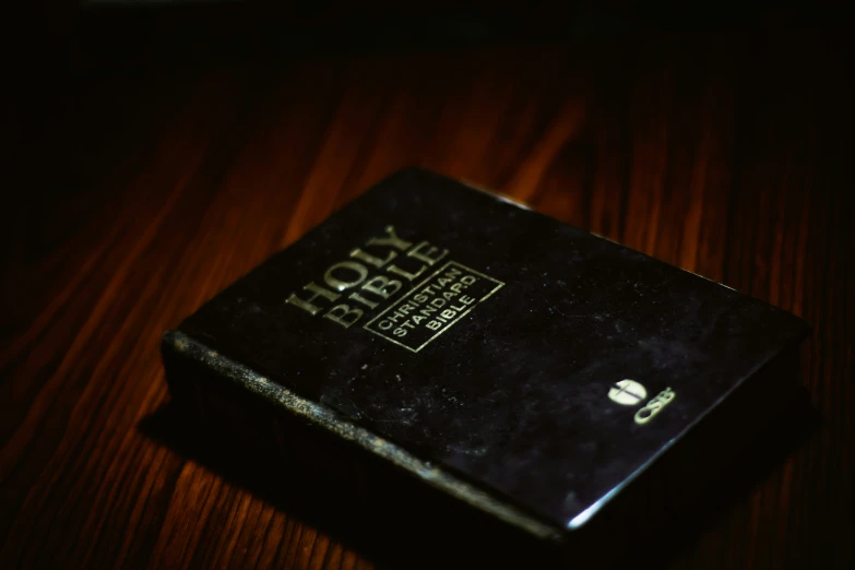 the old bible sits upon a table in a dark room