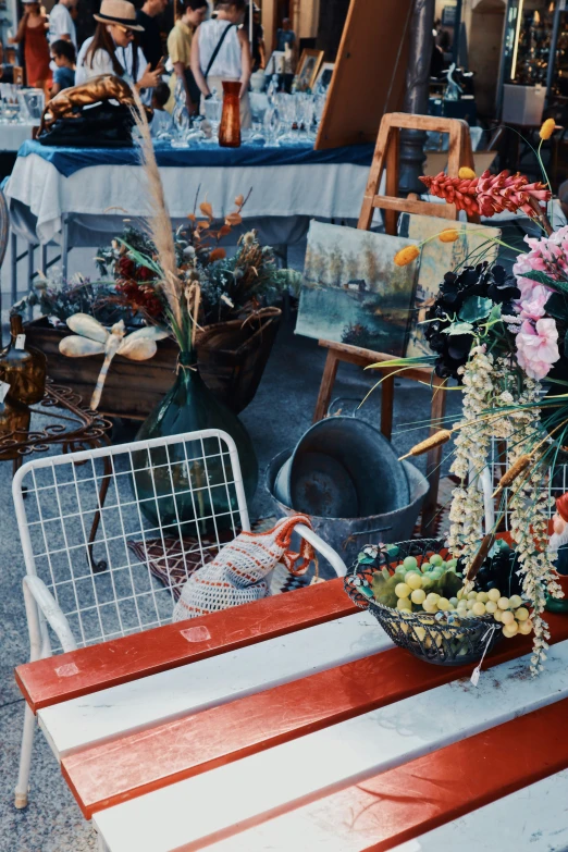 various tables and flowers sitting on display in an outdoor market