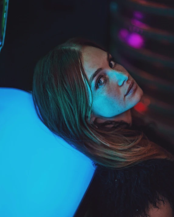 a beautiful young woman with long hair laying on a chair