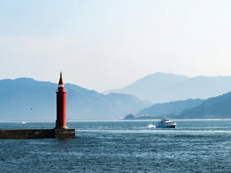 two boats floating on water next to a tall red tower