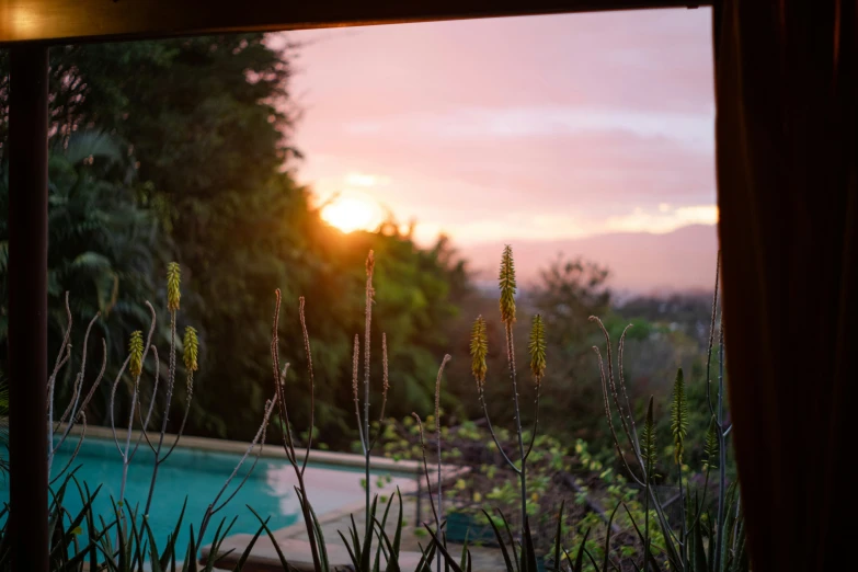 the sun is setting in a secluded pool area