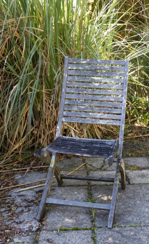 an old chair sitting on top of a stone sidewalk