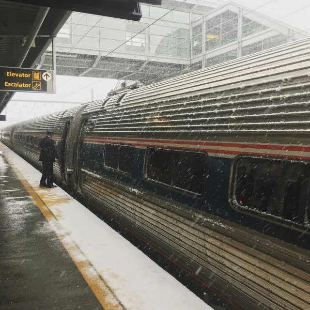 a man standing in the rain while waiting for a train