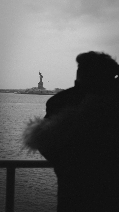 a man taking a po of the statue of liberty from a boat