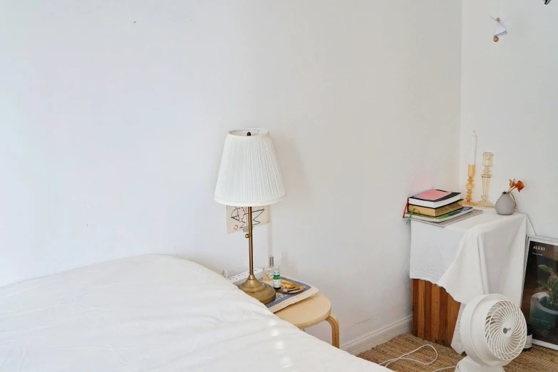 a bedroom with a small fan in the corner