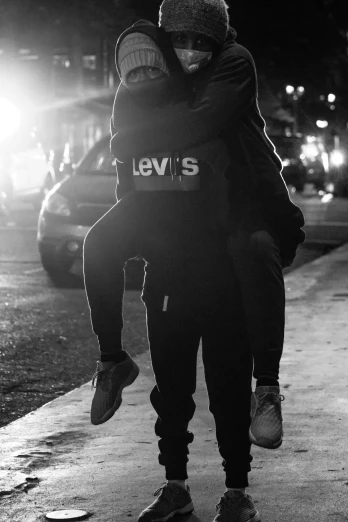 a man is carrying a woman up the sidewalk